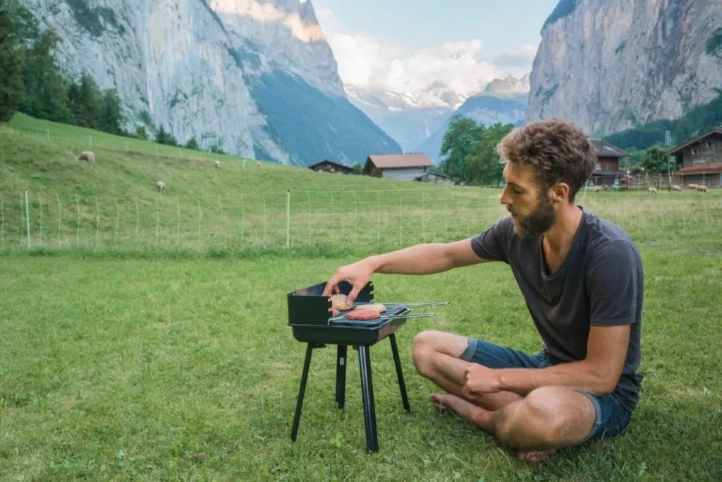 Young Man Using One of the Best Camping Grills