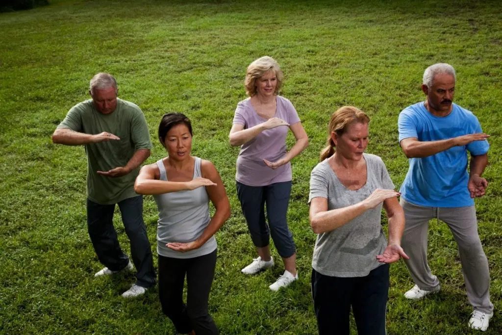 Group learning the benefits of Tai Chi vs Yoga