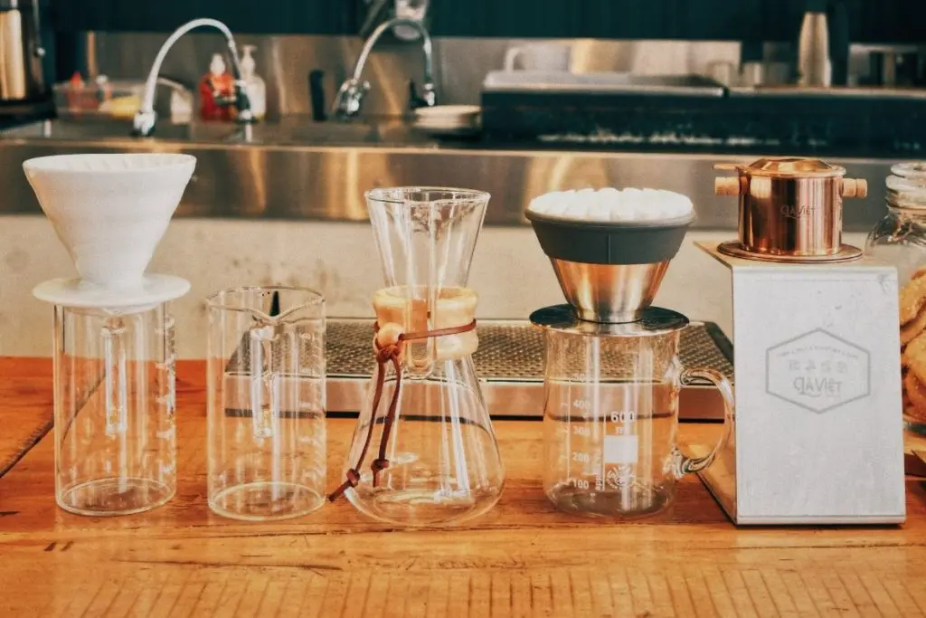 A row of pour over coffee makers with filters