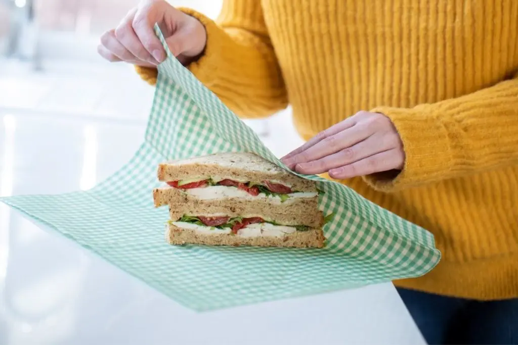 Woman using a reusable food wrap on a sandwich