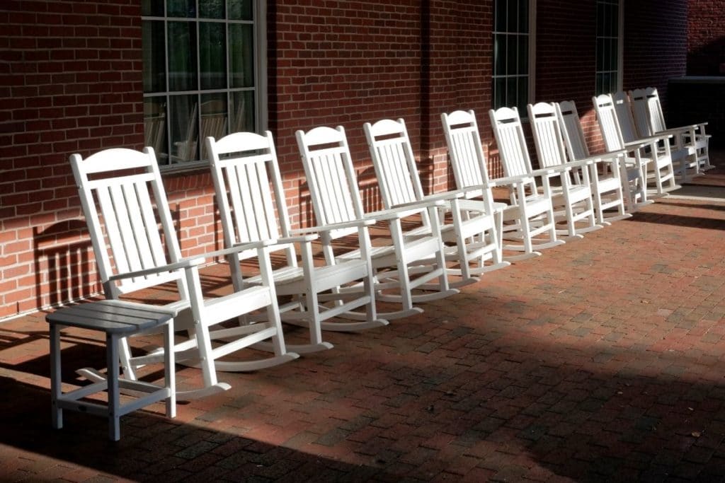 Row of white outdoor rocking chairs