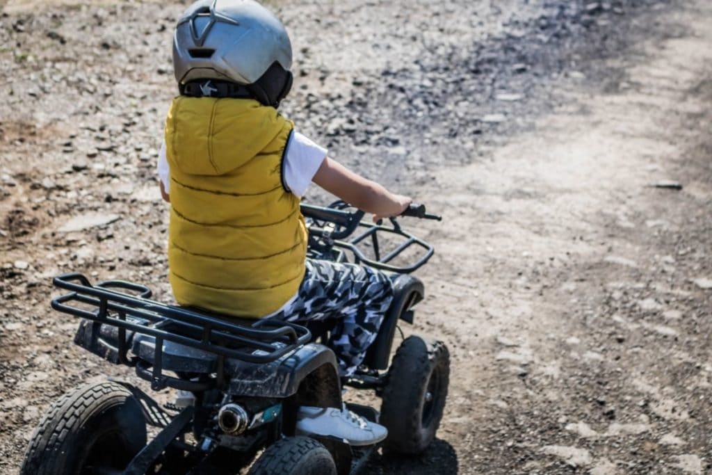 Child in Yellow using one of the best Kids ATVs